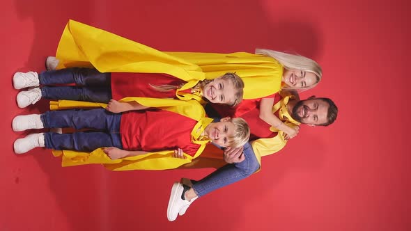 Happy Parents Playing Superheroes with Children.