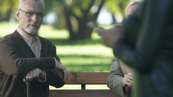 Two Retired Men Looking at Attractive Woman Walking in Park, Friends Having Fun