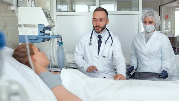 Doctor and Nurse Visiting Young Woman at Hospital