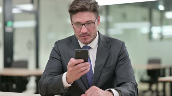 Middle Aged Male Businessman Using Smartphone 