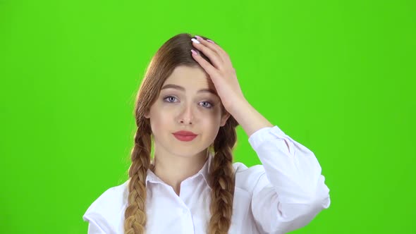 Girl in a White Blouse and Pigtails Shows a Fist. Green Screen