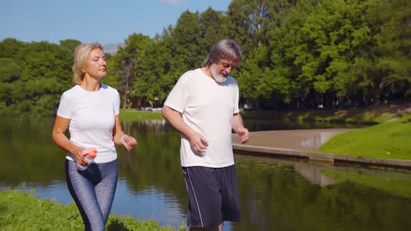 Happy Caucasian Old Couple Jogging Running Outdoors in Park