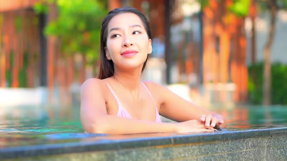 Young asian woman enjoy around outdoor swimming pool for leisure