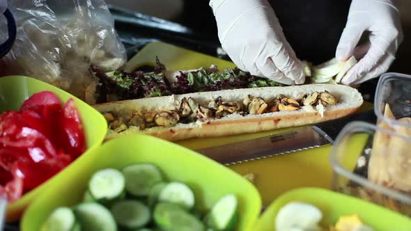 Cook Makes a Sandwich with a Seafood on Festival Street Food