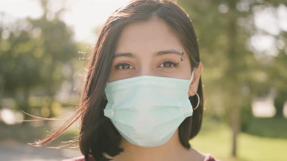 Beautiful woman looking at camera with medical mask