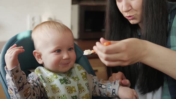 Young Mother Feeding Her Baby Son