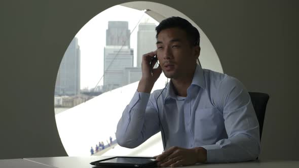 MS Businessman using digital tablet while talking on phone in office