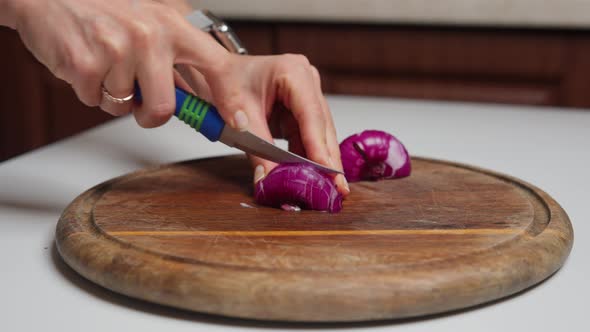 Woman Cuts Onion on a Cutting Board for Cooking Homemade Vegetable Salad