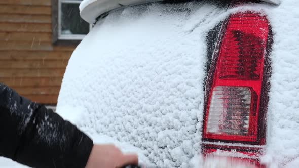 Person Brushing Snow From Car After Snow Storm Blizzard