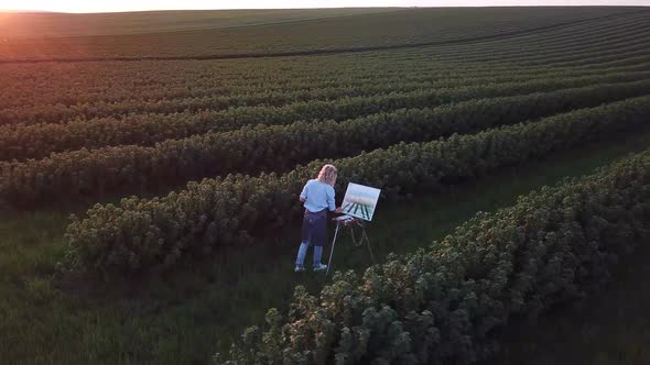 Girl artist paints a picture with oil paints.