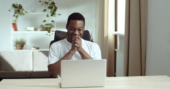 Handsome African American Man Celebrating Success While Sitting at Home in Office with Laptop. Black