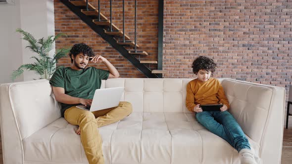 Curlyhaired Brothers Spend Time at Home Using Gadgets