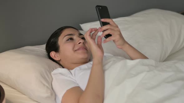 Smartphone Use By Indian Woman Laying in Bed