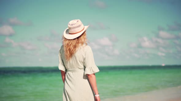 Woman Relaxing On Bahamas Flowing Dress Blowing In Wind.Travel Mood Wind Blows Dress On Ocean Resort