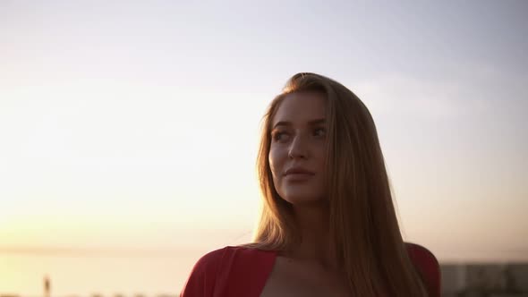 Footage From Above of a Young Blonde Haired Woman Standing Near the Sea or Ocean in Morning Dusk