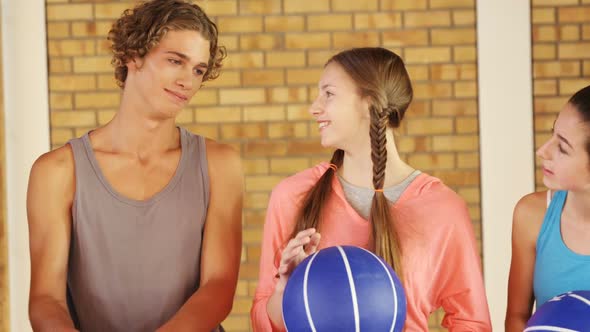 High school kids with basketball standing together in basketball court