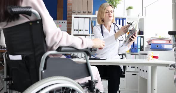 Doctor Examining Xray of Disabled Patient in Wheelchair  Movie Slow Motion