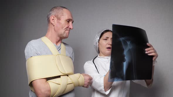 Orthopedist Shows Xray Photograph to Patient with Bandage