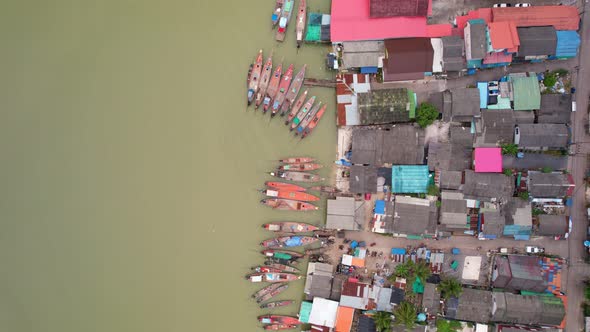 Aerial view top view of the fisherman village with fishing boats and house roof at the pier