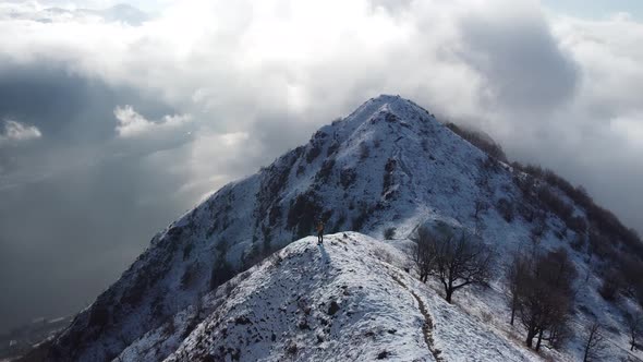 Hiker on top of the snowy mountain ridge, Monte Barro, Lecco, Italy