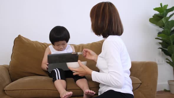 Young mother with her little son spending time together at home.