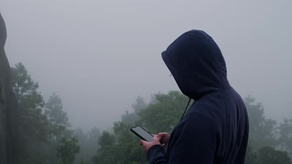 Young man traveler in navy blue male hoodie sweatshirt long sleeve using a smartphone.