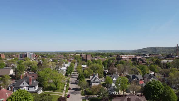 View down street of older neighborhood with well maintained homes and yards looking toward mountain.