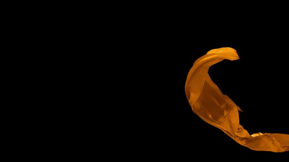 Orange fabric flowing on black background, Slow Motion