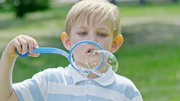 Cute Boy Blowing Bubbles Outdoor alt