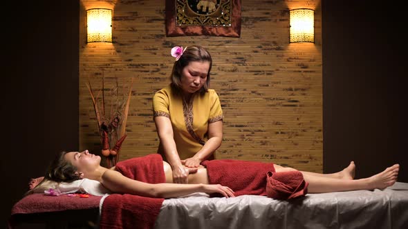 Thai massage session. Thai woman massage young beautiful woman