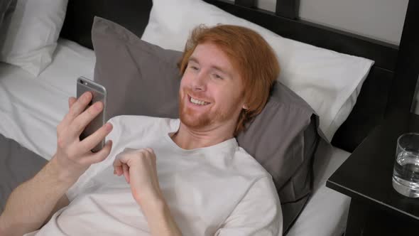 Online Video Chat by Redhead Man Lying in Bed