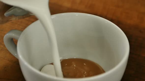 Pouring Stream Milk Into a Cup of Coffee