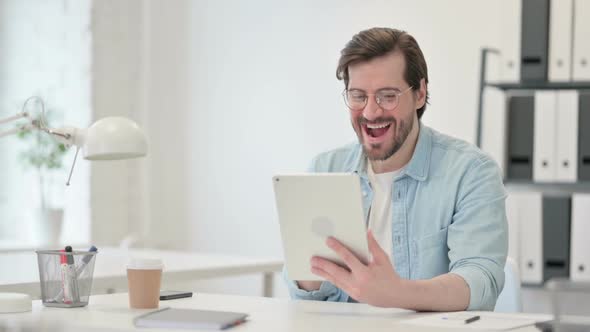 Successful Man Celebrating on Tablet at Work