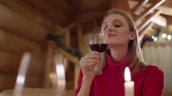 Young woman toasting and drinking wine