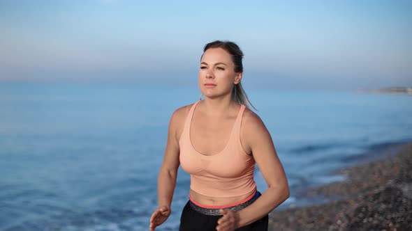 Athletic Young Female in Sportswear Running at Morning Nature Beach