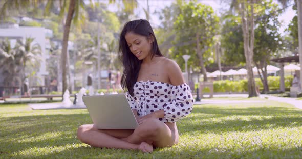 Smart Asian Woman Typing on Laptop Sitting in Grass in Park