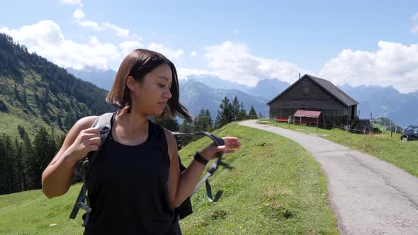 Active Woman On A Hike Puts On Backpack and walking the natural trail in Switzerland.Close up shot.