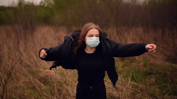 Woman in a Mask Puts on a Jacket at Nature Pandemic Covid19 Coronavirus
