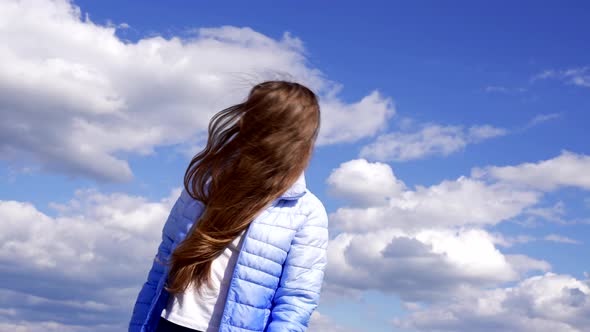 Happy Child in Autumn Jacket Showing Long Hair on Sky Background Freedom