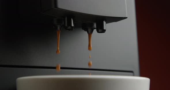 Coffee Pouring Down To A White Cup From A Coffee Machine In Slow Motion With Terracotta Background