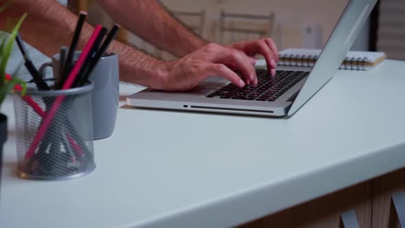 Close Up of Man's Hands Typing on Laptop