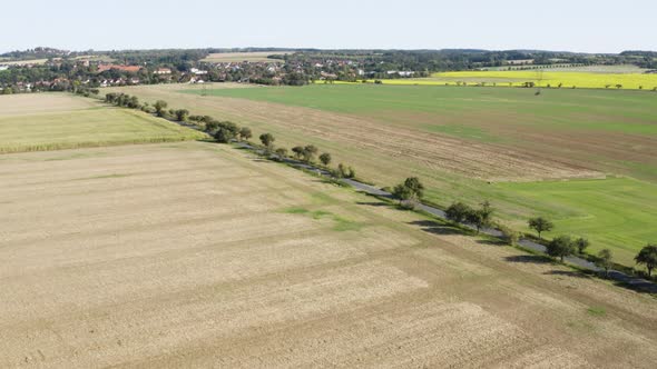 Aerial Drone Shot  a Rural Area with Fields and a Road  a Town in the Background