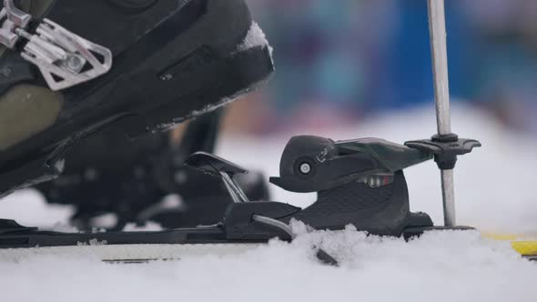 Side View Closeup of Female Ski Boot Putting on Ski