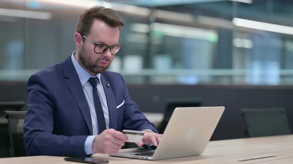 Successful Online Shopping on Laptop By Middle Aged Businessman