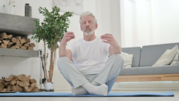 Peaceful Old Man Meditating on Yoga Mat at Home