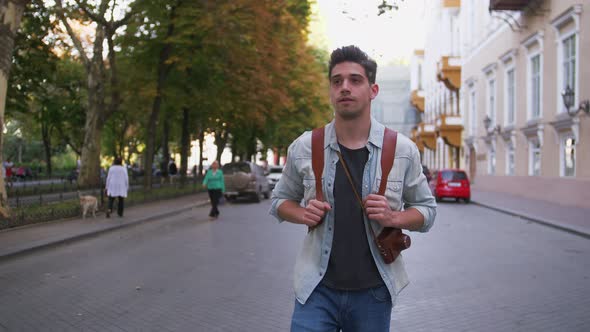 Attractive Young Handsome Man Tourist with Backpack Walking in City Center