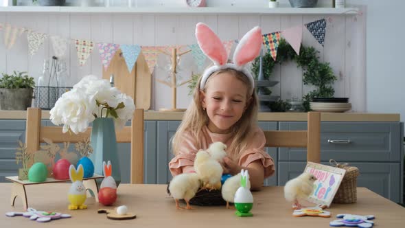 Little Girl in Bunny Ears Playing with Chickens