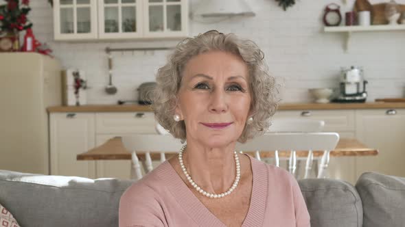 Portrait of a Beautiful Modern Elderly Woman Turns Her Head Looks at the Camera and Smiles Close Up