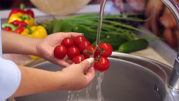 Close-up of a Woman Washing Cherry Tomatoes Under Water in the Kitchen Sink