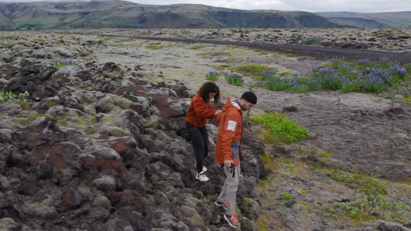 Drone Of Couple Holding Hands In Mossy Landscape